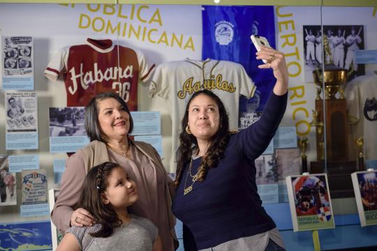 Three members of a family taking a selfie in the Viva Baseball exhibit
