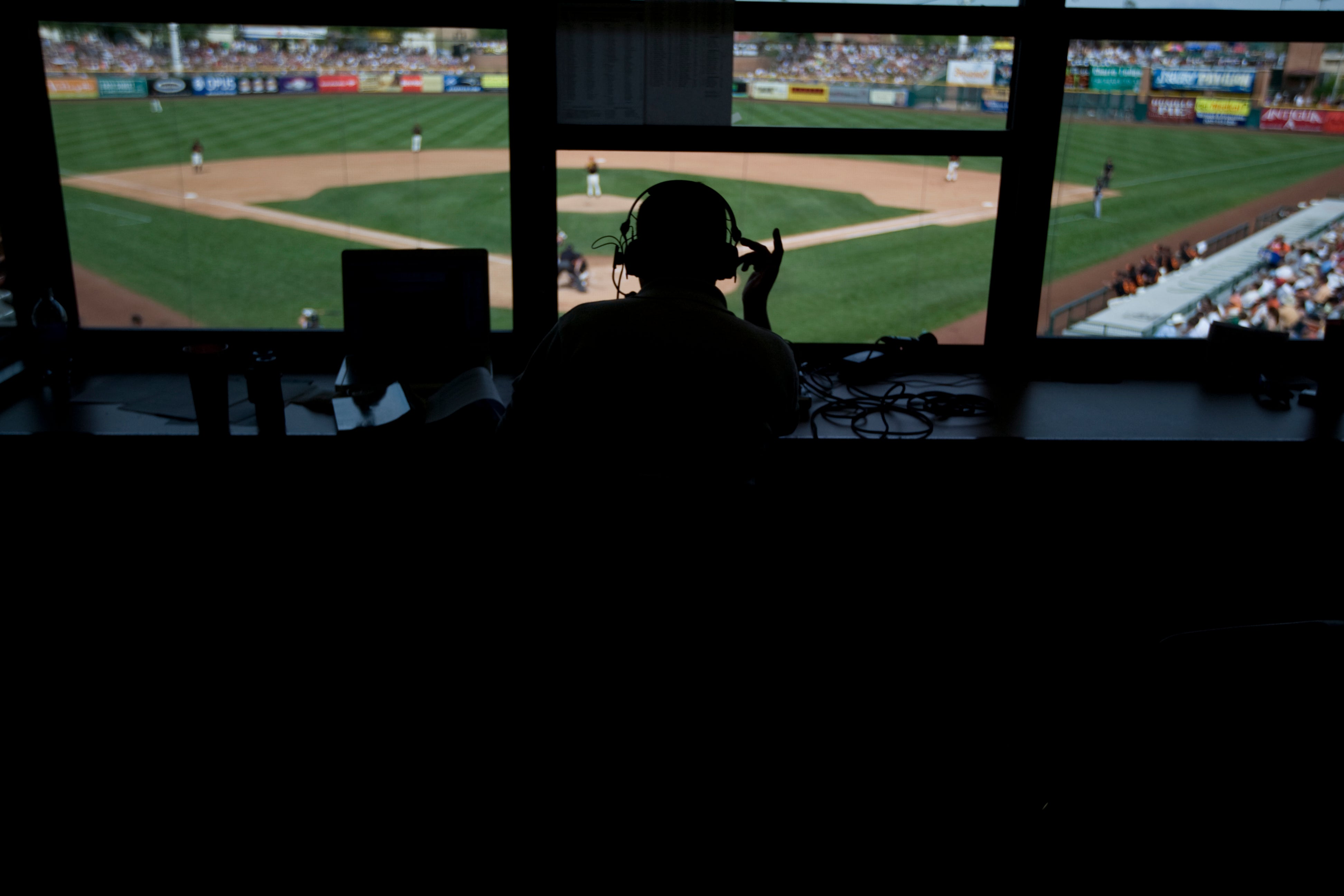 A broadcaster, with the field visible in the background. 